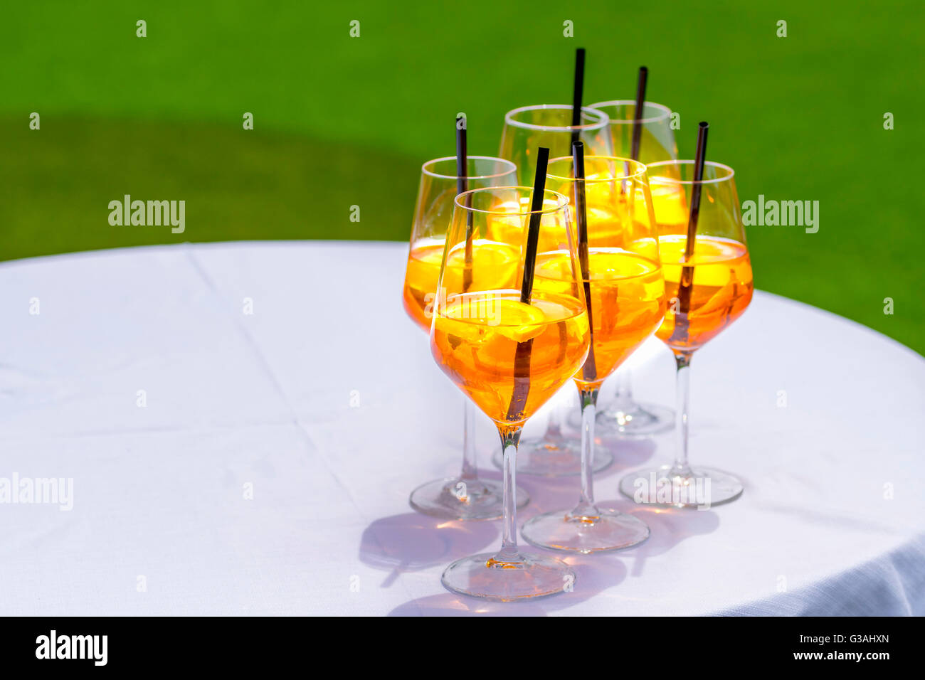 Popular Italian aperitif made with prosecco, orange bitter and soda, decorated with orange slices.Several glasses on white table Stock Photo