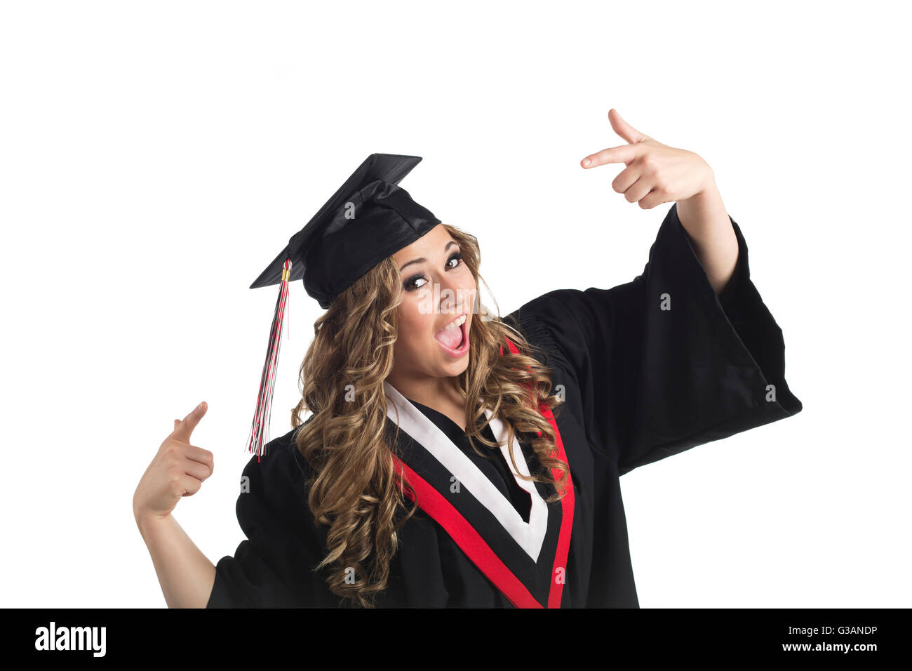 Young female graduate pointing at her grad cap in celebration; Edmonton