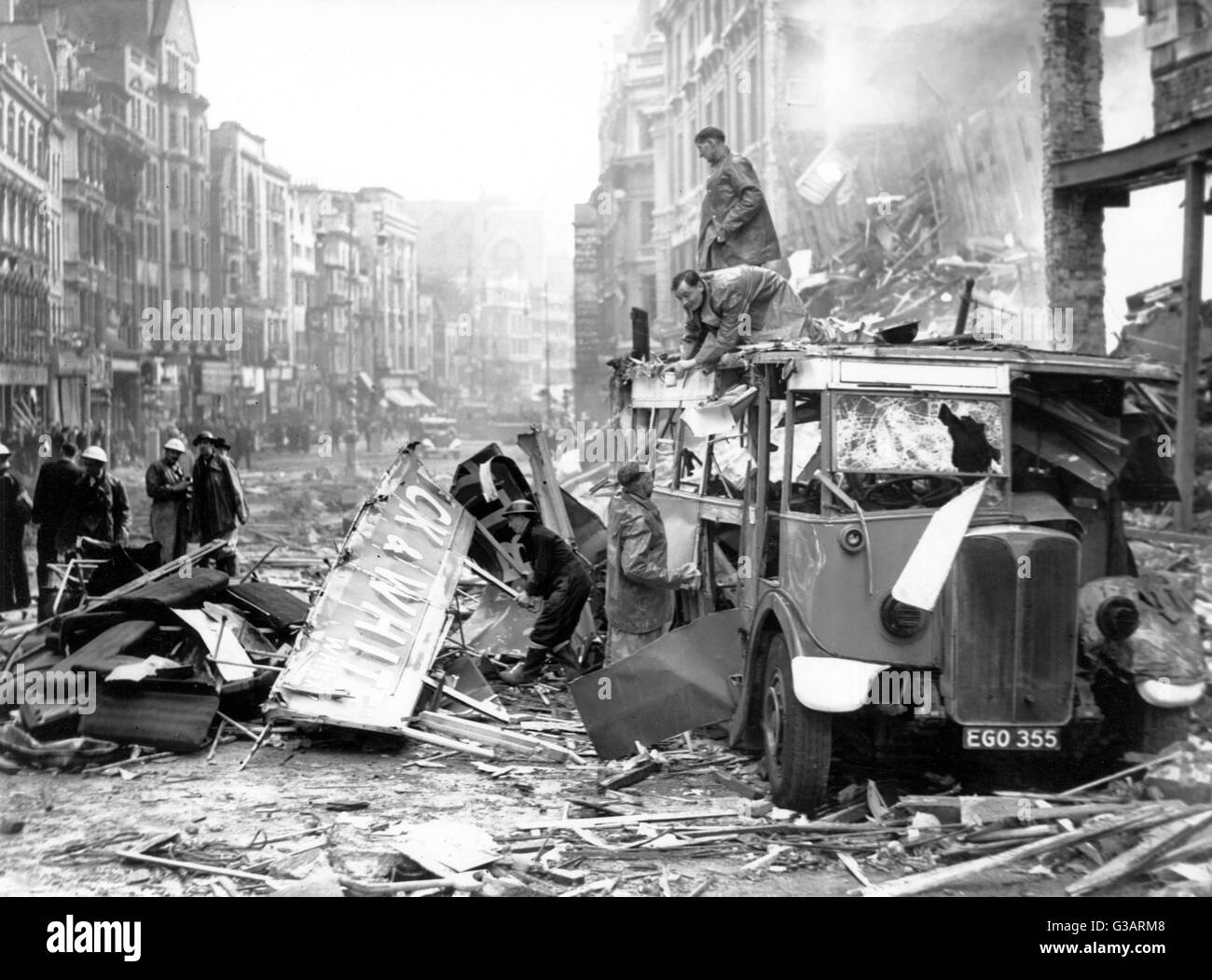 Blitz in London -- aftermath of bombing, with men clearing up around a shattered bus.      Date: 1940s Stock Photo