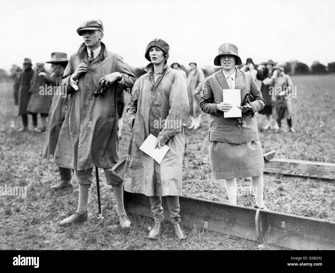 Countryfolk at a meet of the  Avon Valley Coursing Club  (near Salisbury) - he in plus- fours and gaiters with a cloth  cap, his companion in high  boots and heavy raincoat     Date: 1927 Stock Photo