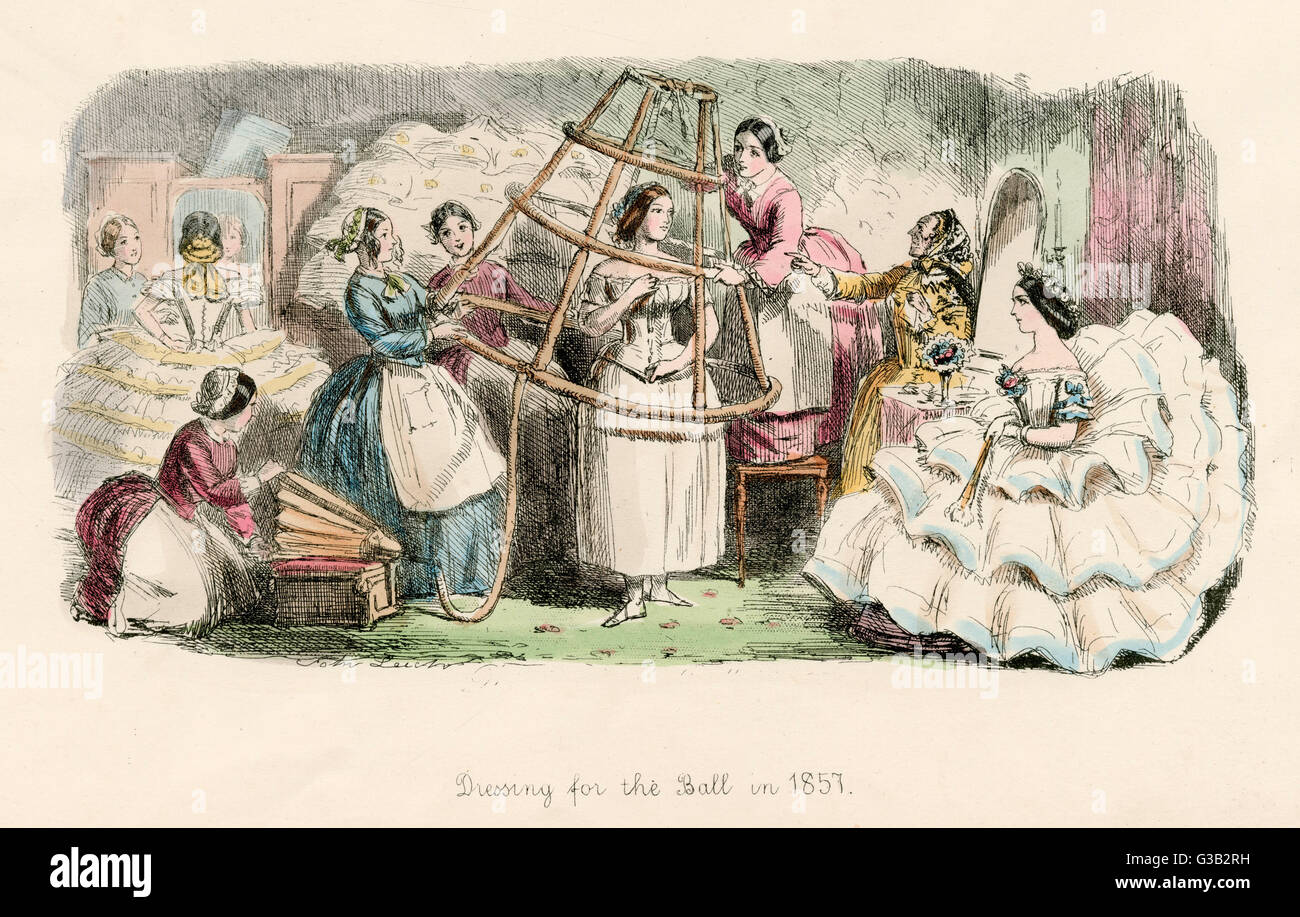 Dressing for the ball, a team of helpers gather round to help rhe daughter of the  house into her crinoline       Date: 1857 Stock Photo