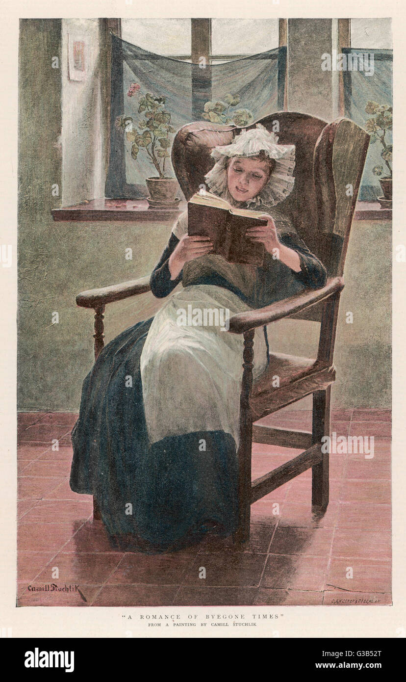 WOMAN READS IN LACE HAT Stock Photo