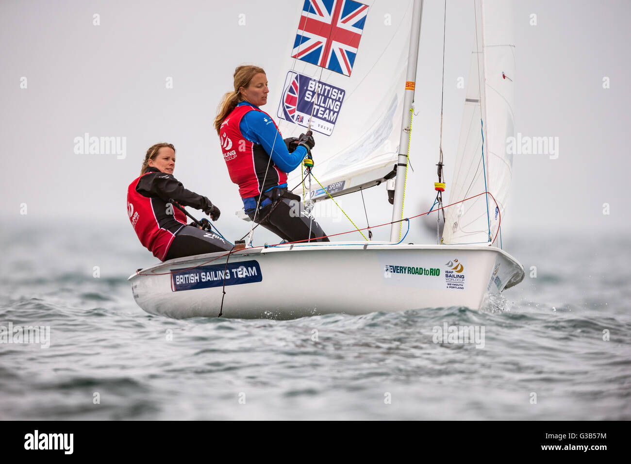 Team GBR Olympic sailors Hannah Mills (left) and Saskia Clark pictured racing their 470 Women's class dinghy on day two of the ISAF Sailing World Cup at the Weymouth and Portland National Sailing Academy, Weymouth. Stock Photo