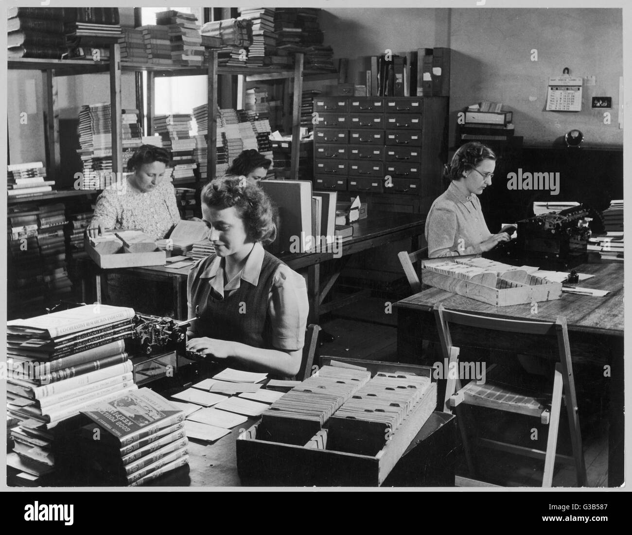A model of tidiness and  application, this public  library office is neatly and  sparsely laid out; its  female staff appear to be  absorbed in their work.     Date: 1947 Stock Photo