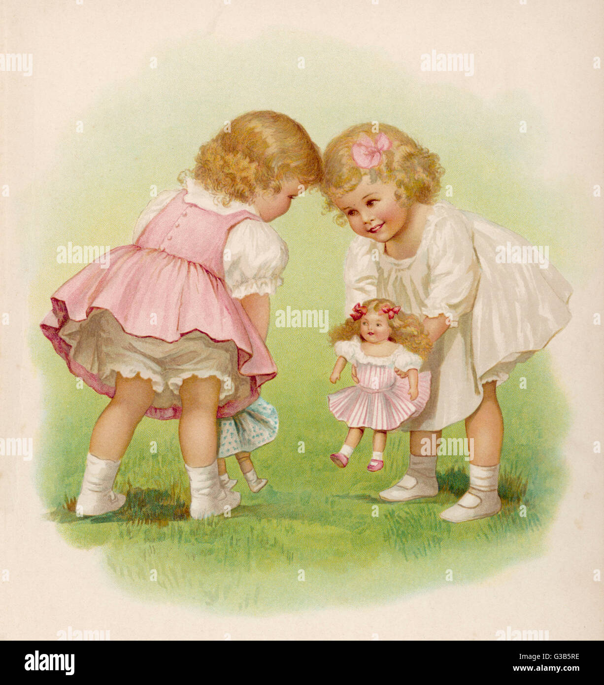 Two young girls introduce their dolls to each other Stock Photo