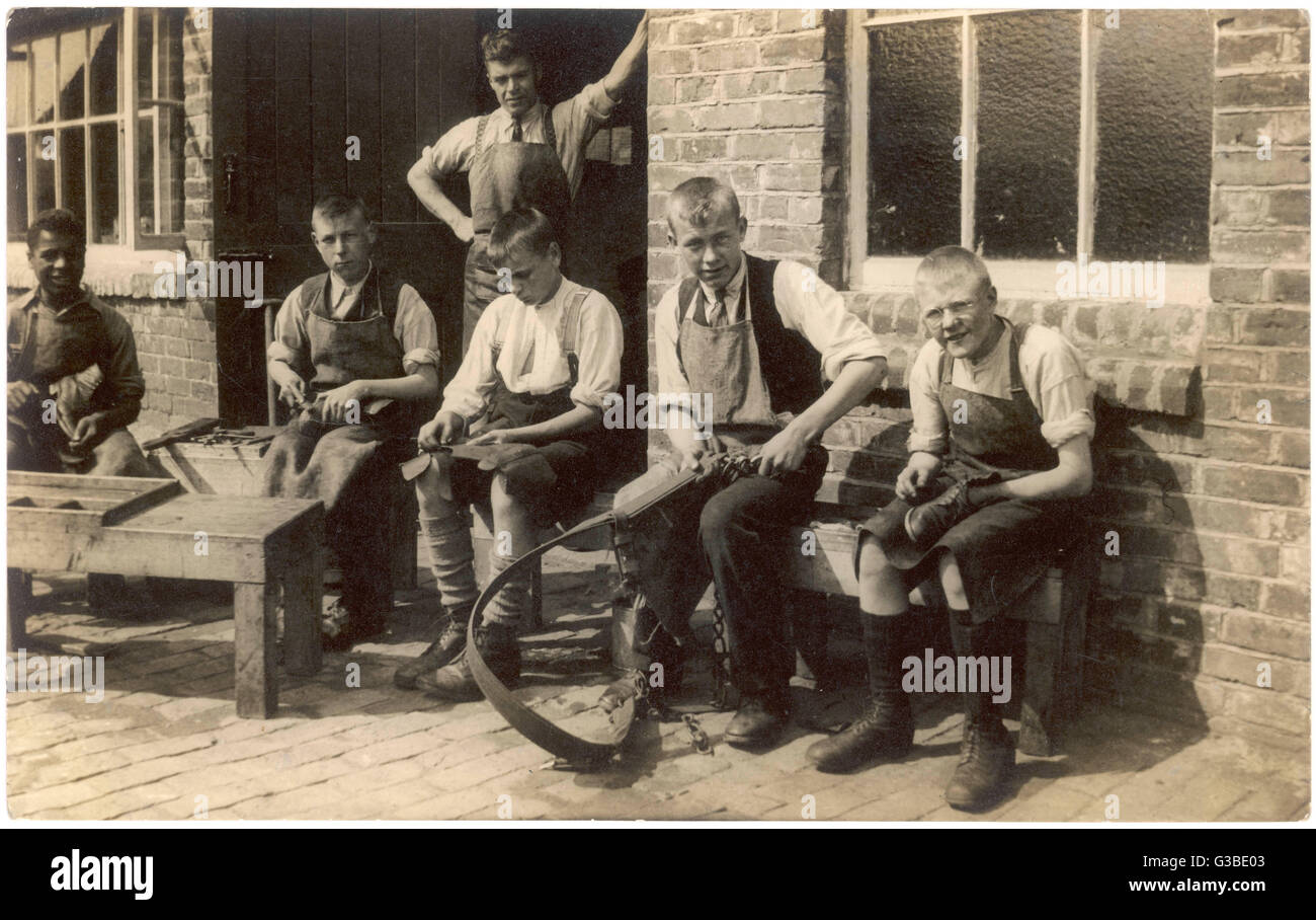 A group of apprentices  learning various tasks in a  rural setting.        Date: circa 1900 Stock Photo