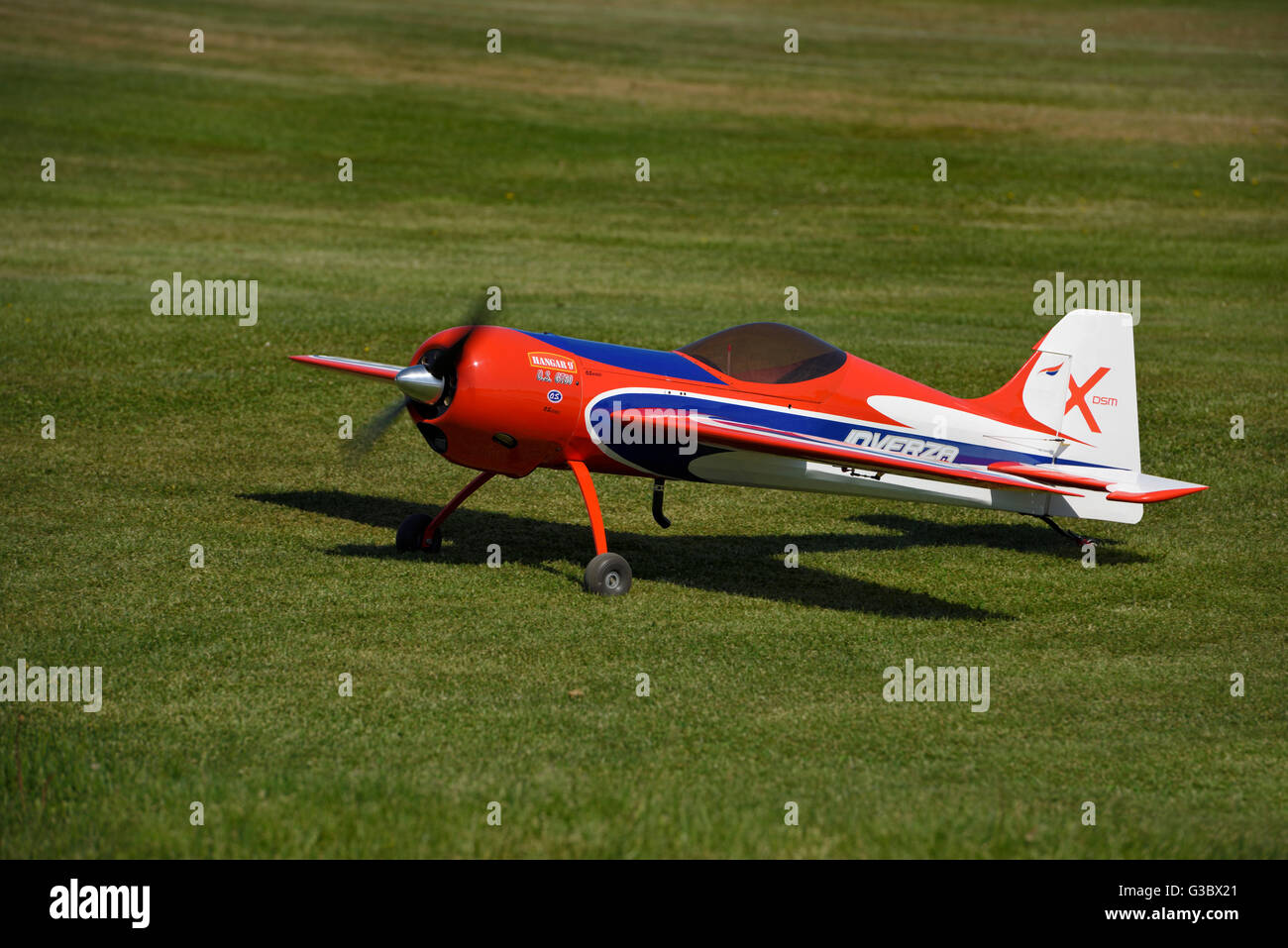Radio controlled single propeller aircraft taxiing on grass runway Stock Photo