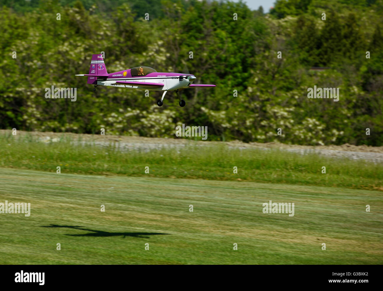 Single Prop radio controlled scale model aircraft landing on a grass runway Stock Photo