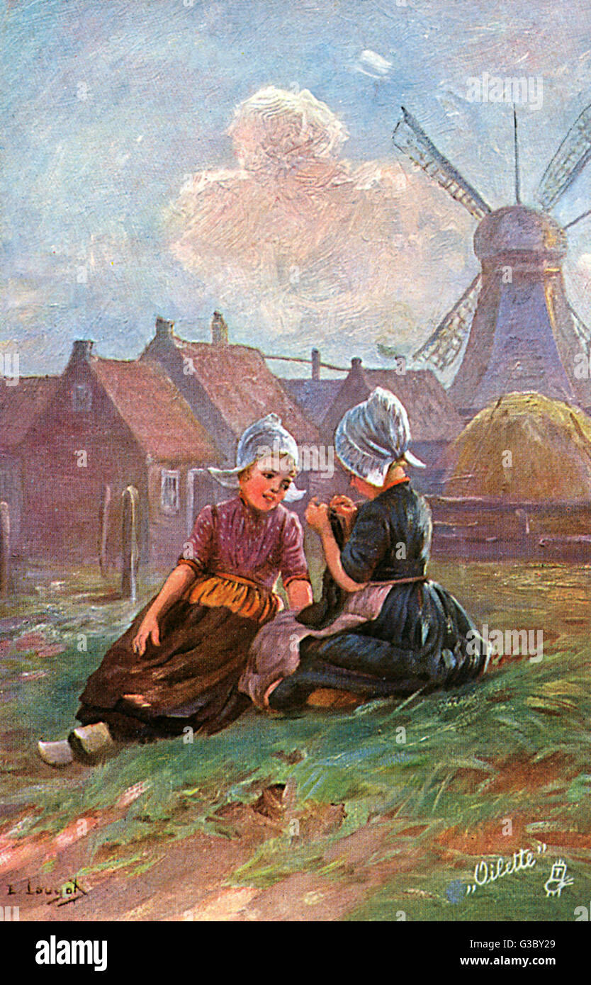 Dutch Peasant Girls knitting their Father a pair of socks. Classic Dutch scene (including obligatory windmill) visible in background     Date: circa 1910s Stock Photo
