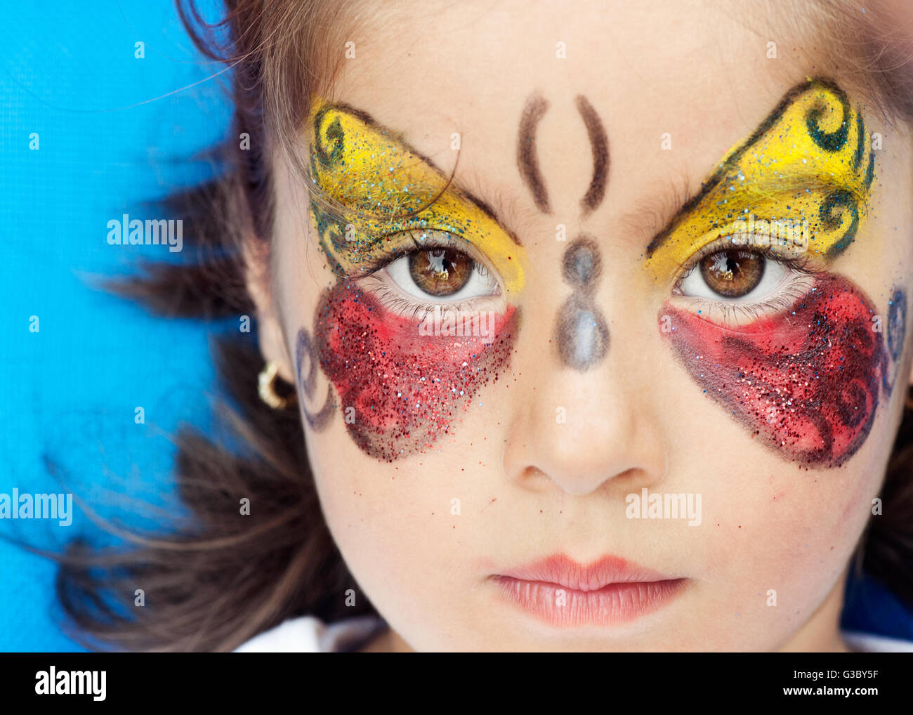 beautiful girl face painted with blue paint with glitter. Stock