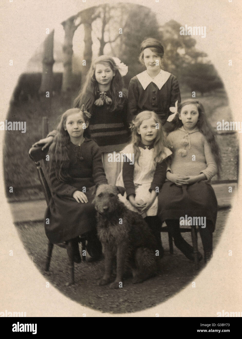 Five girls and dog in garden Stock Photo