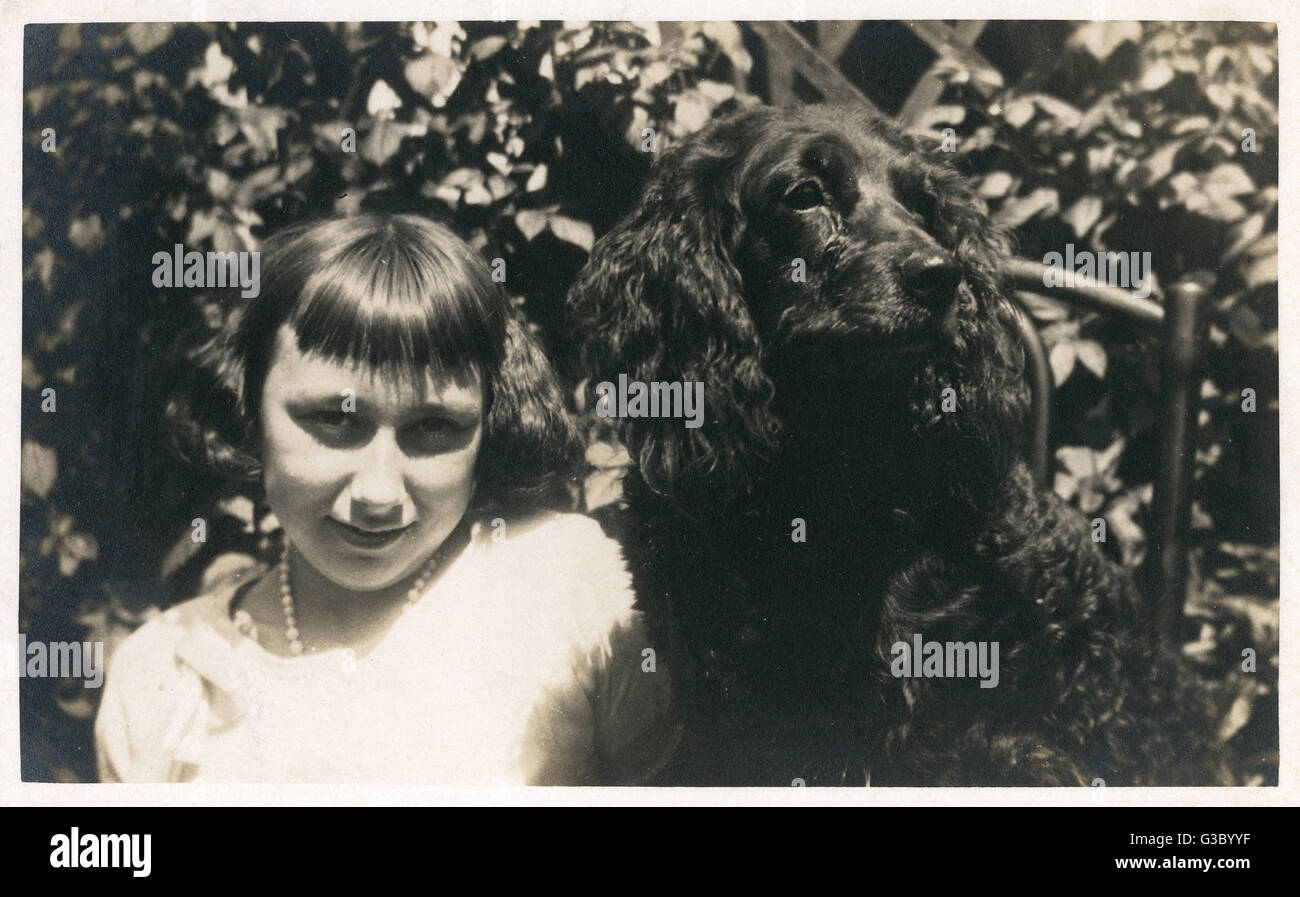 Little girl with black spaniel dog Stock Photo
