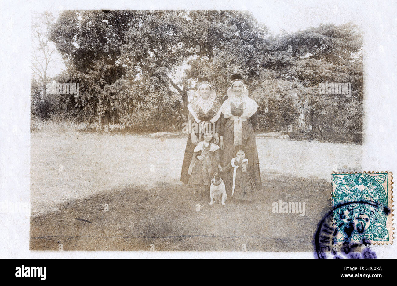 Two women and two children in a garden, with a dog Stock Photo - Alamy