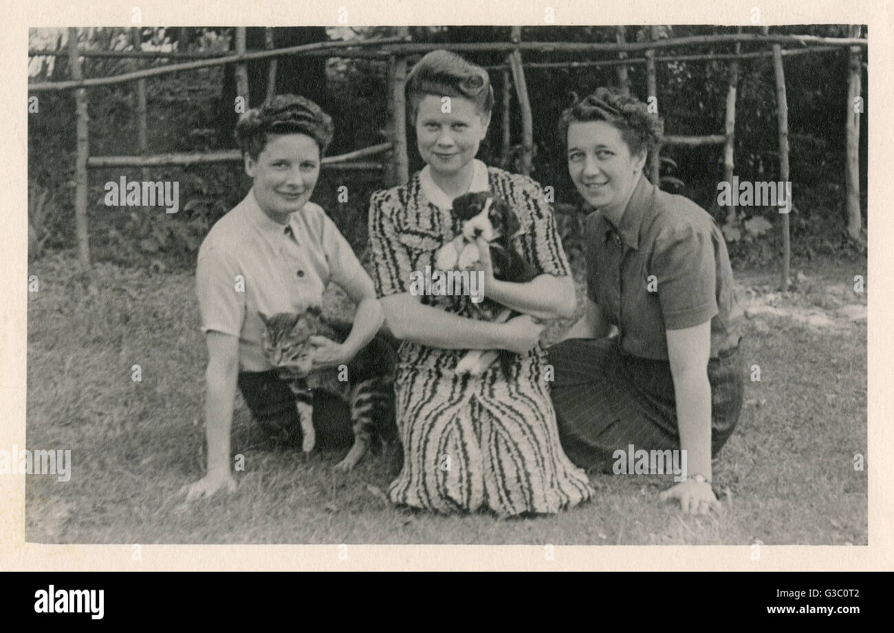 Three women with cat and puppy in a garden Stock Photo - Alamy