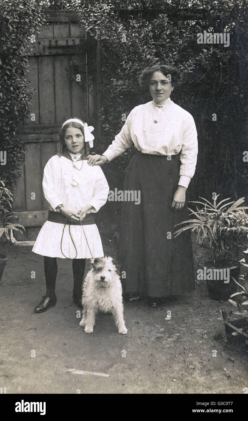 Woman and girl with dog in a garden Stock Photo - Alamy