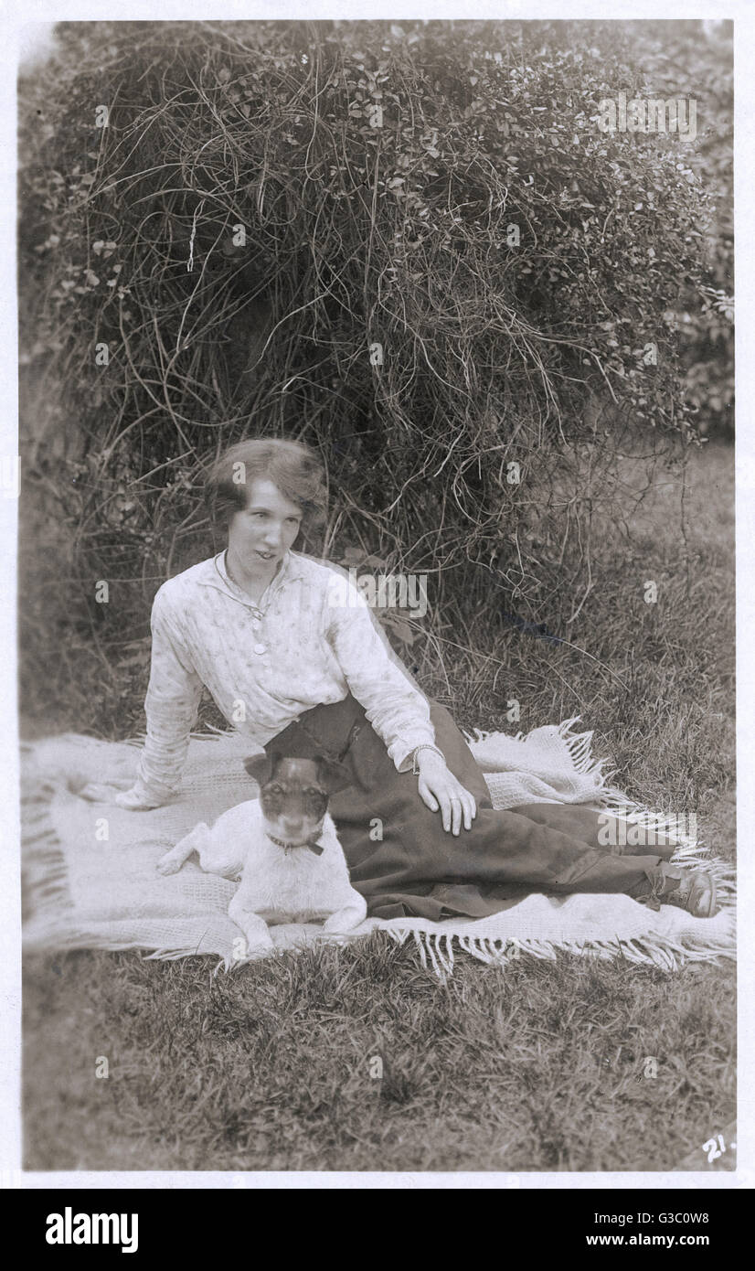 Young woman with a dog in a garden Stock Photo - Alamy