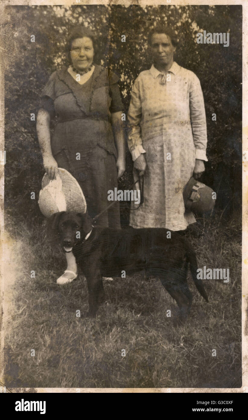 Two women with a dog in a garden Stock Photo - Alamy