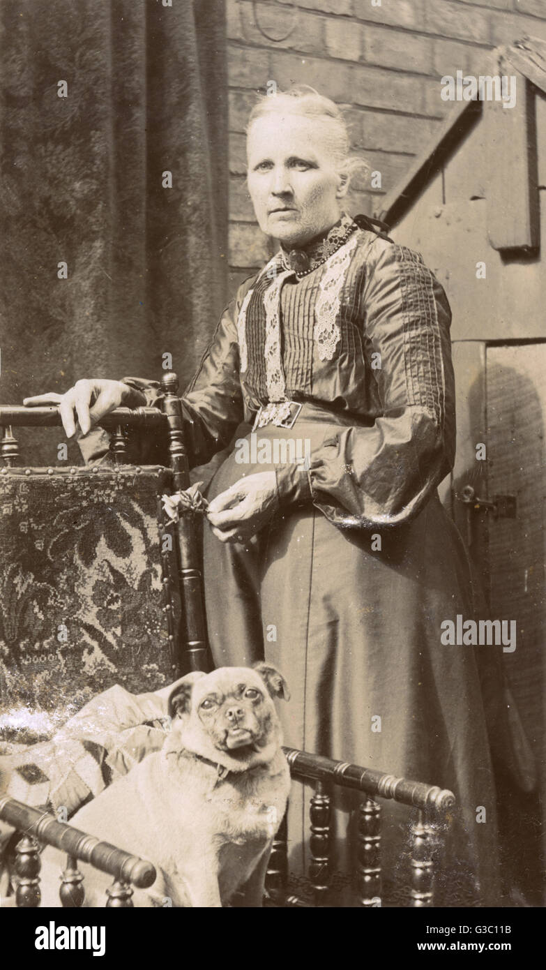 Woman with a dog in a back garden Stock Photo - Alamy