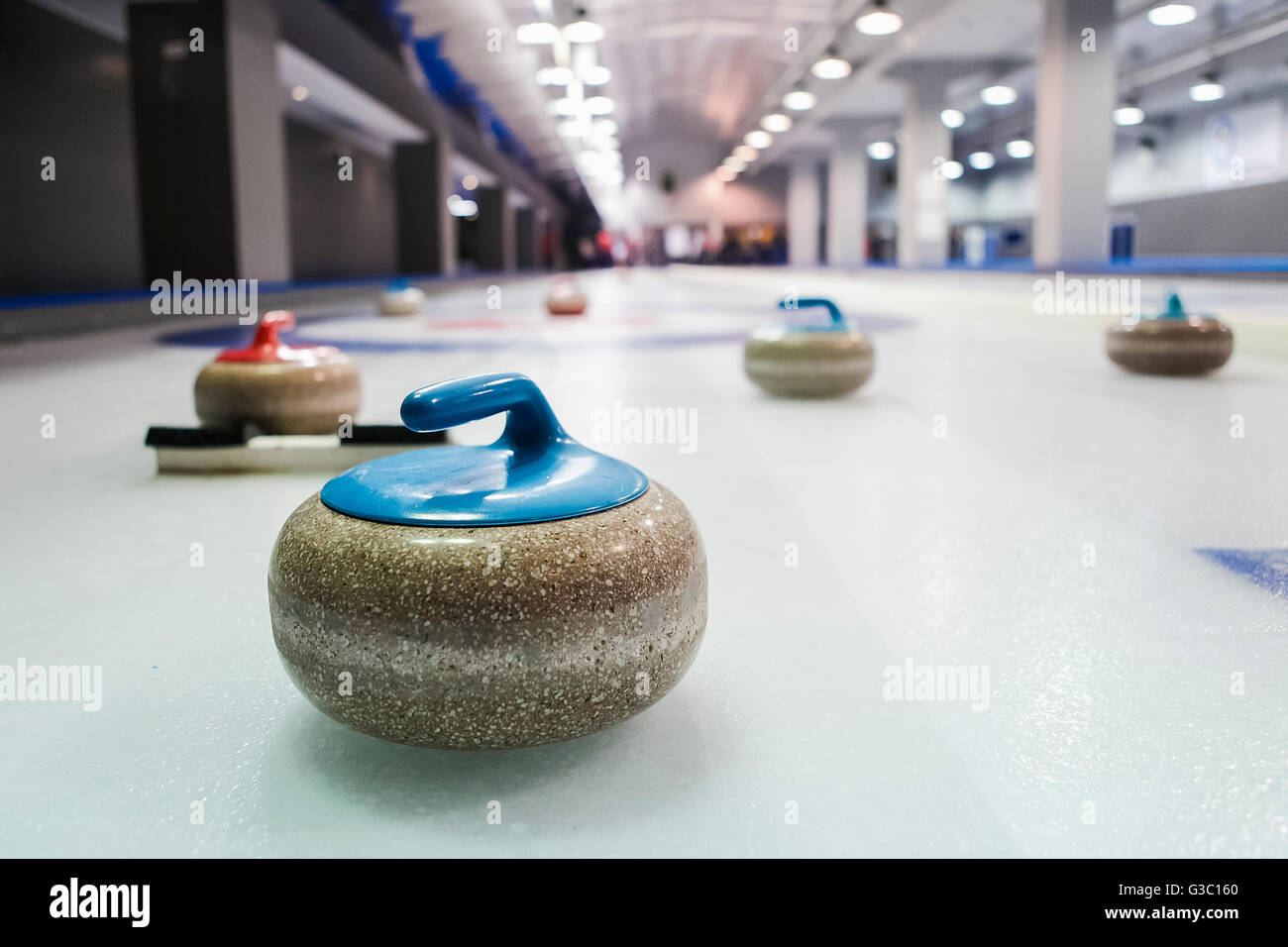 Curling stones lined up on the playing field Stock Photo