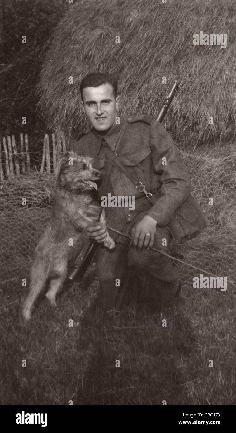 Man in uniform with a terrier dog at a farm Stock Photo