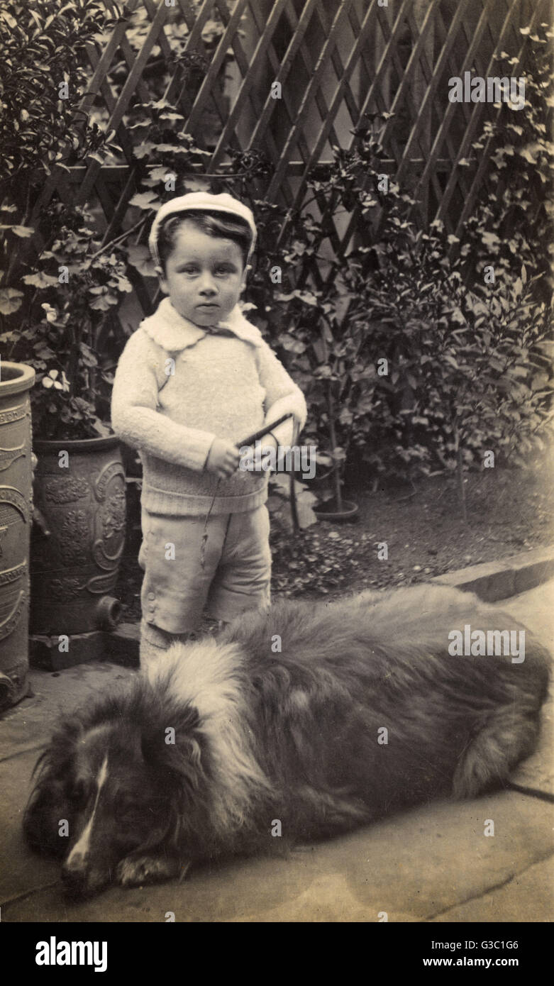 Little boy with large dog in a garden Stock Photo