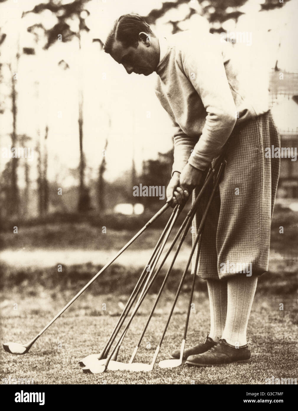 Sir Thomas Henry Cotton (1907-1987), English professional golfer who won three Open Championships, seen here on a golf course checking his clubs and putters.      Date: circa 1930s Stock Photo