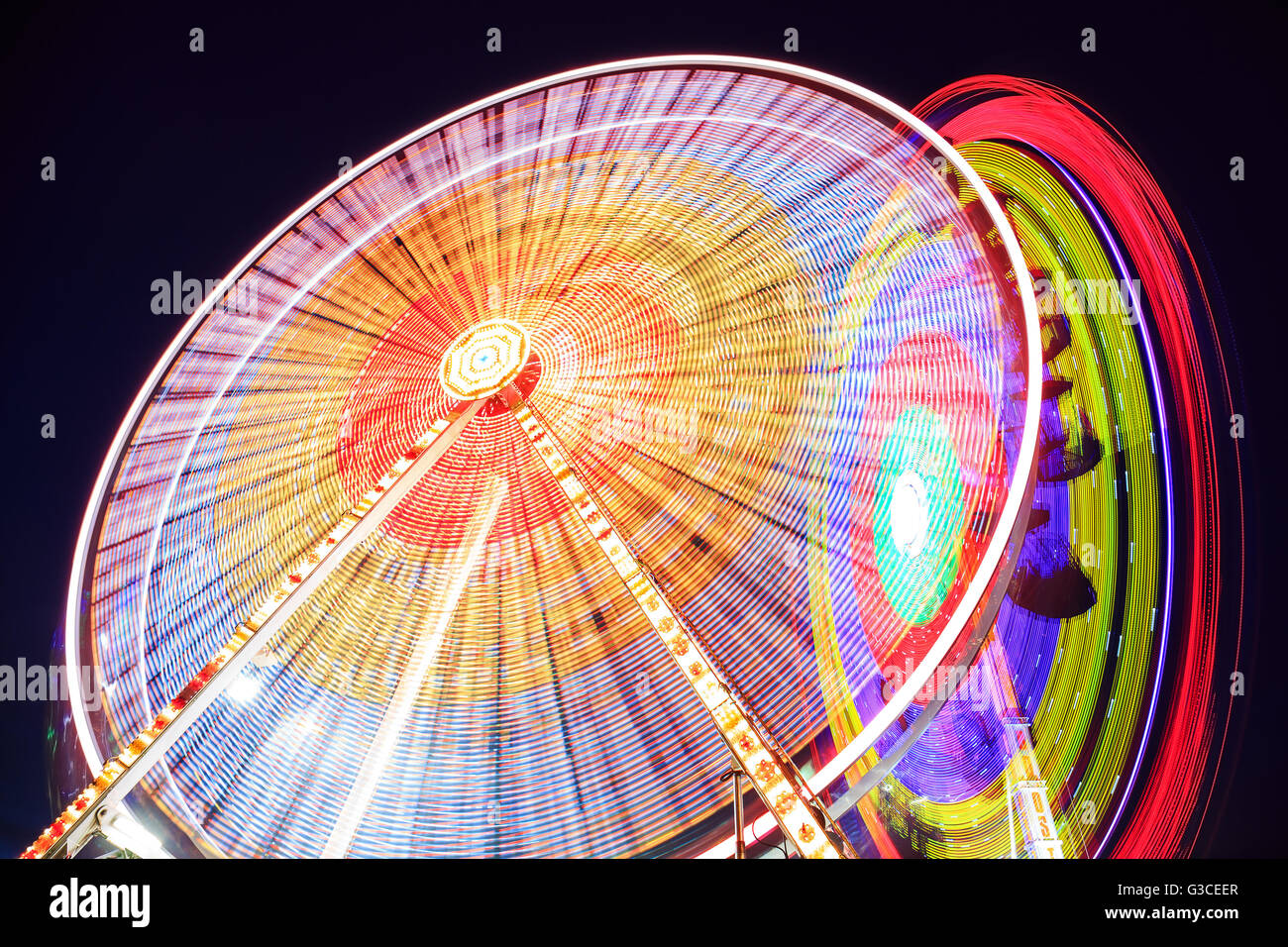 Amusement park at night - Ferris wheel in motion Stock Photo - Alamy