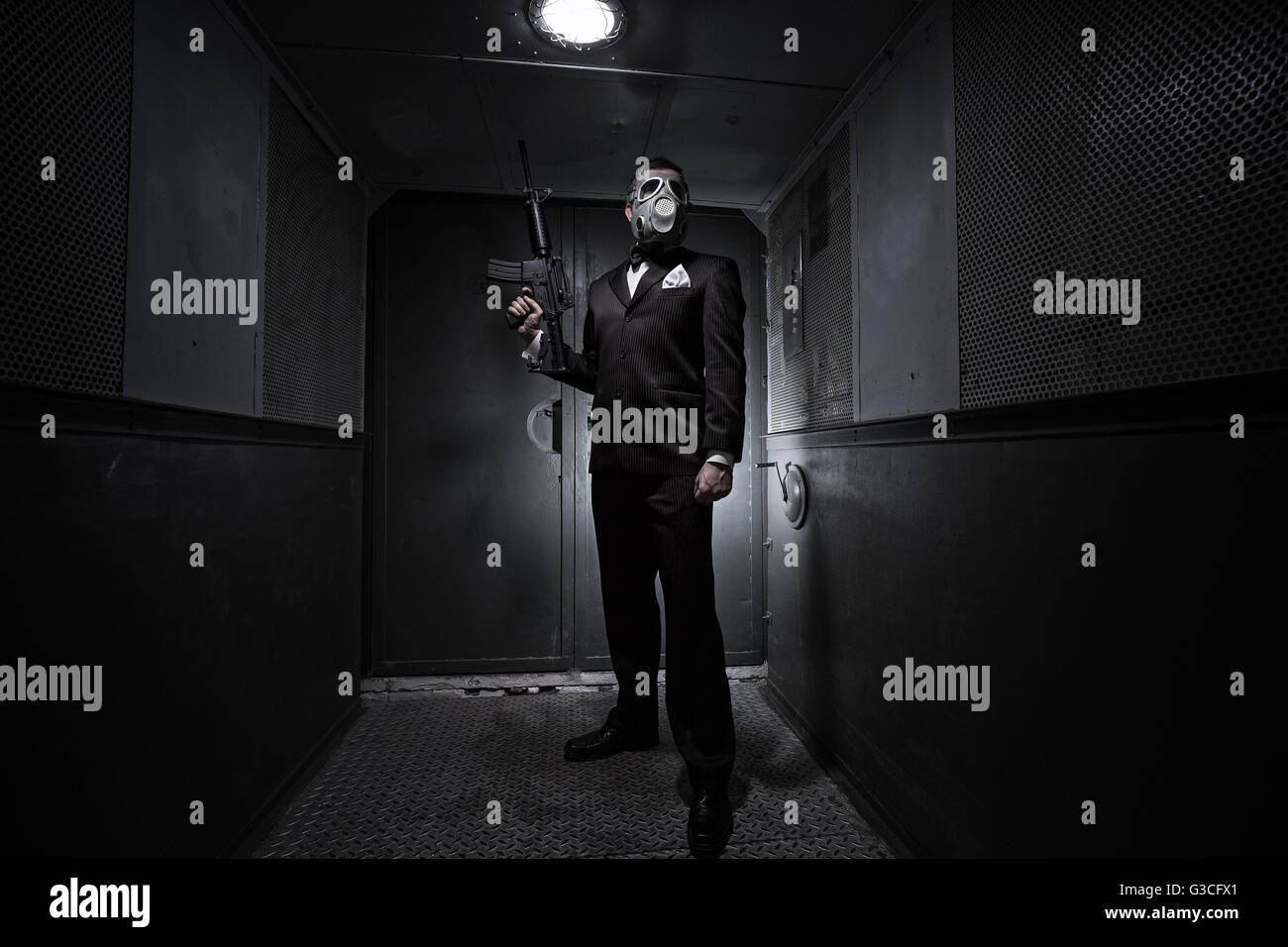 Male with the rifle and gas mask in an old elevator Stock Photo