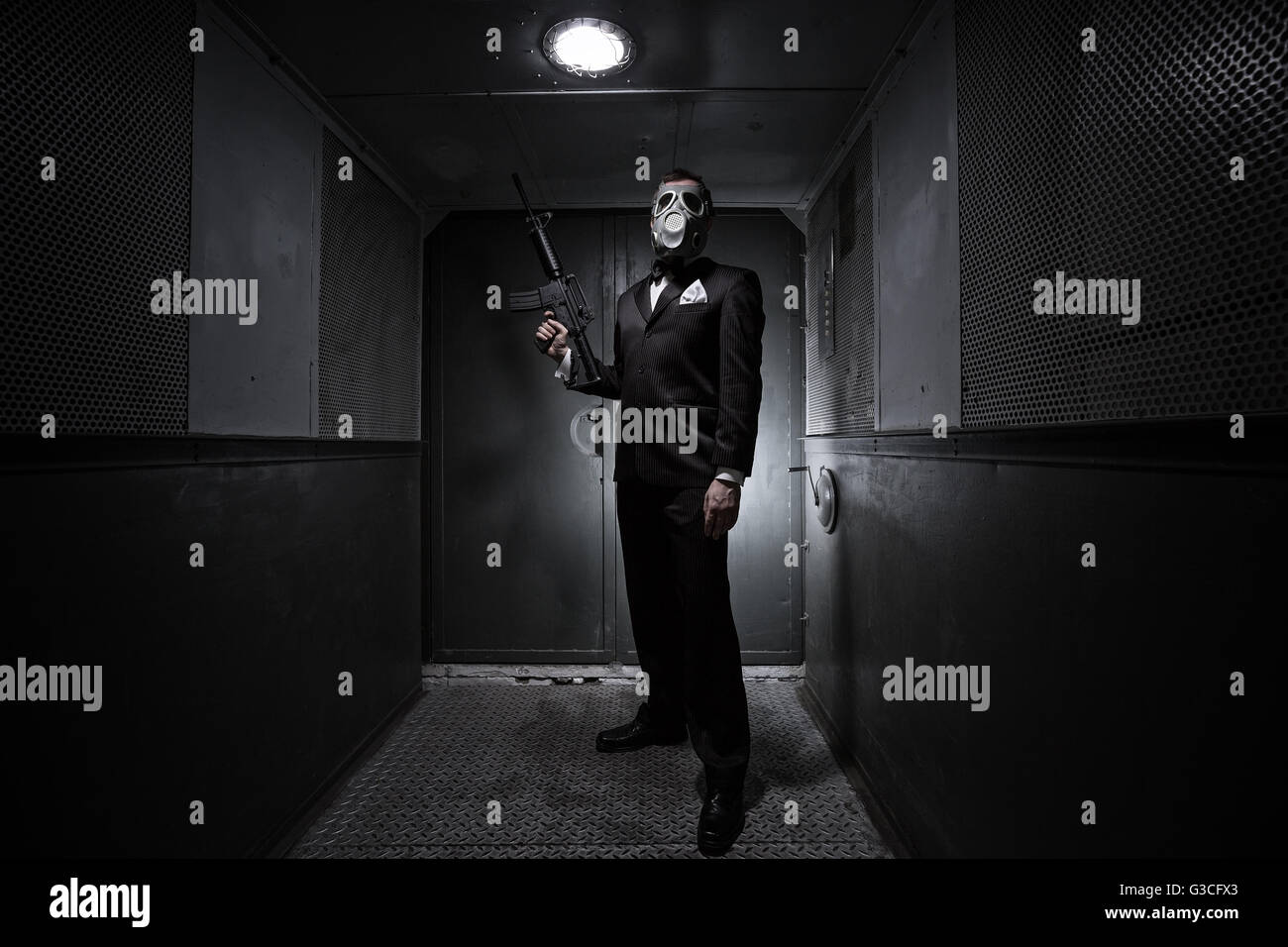 Male with the rifle and gas mask in an old elevator Stock Photo