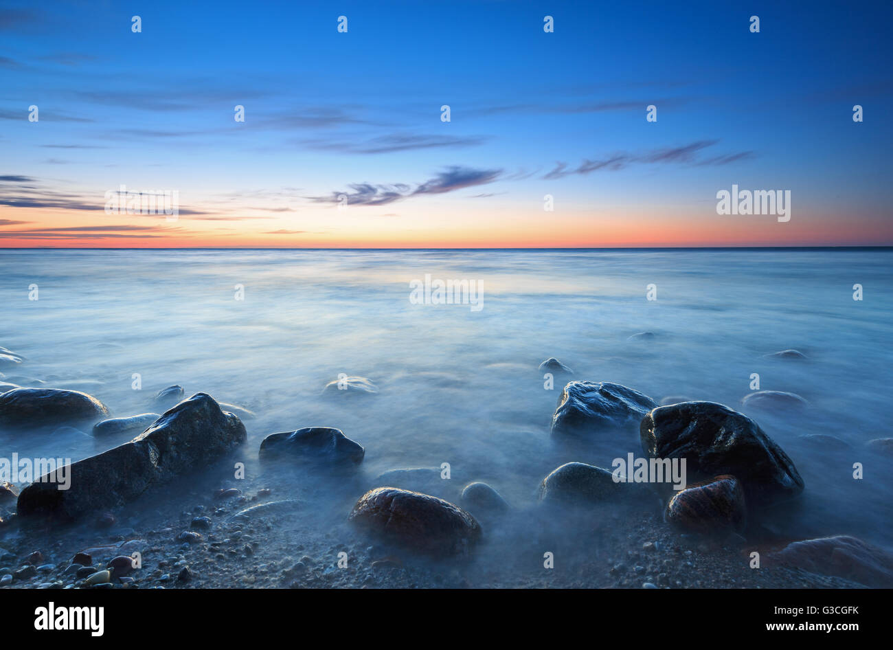 Sunset over the Baltic sea. The pebbly beach in Rozewie Stock Photo
