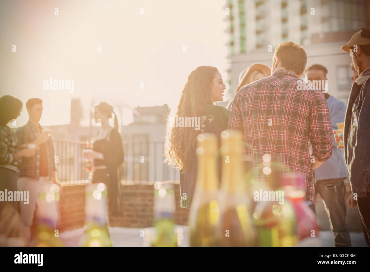 Young adult friends socializing at sunny rooftop party Stock Photo