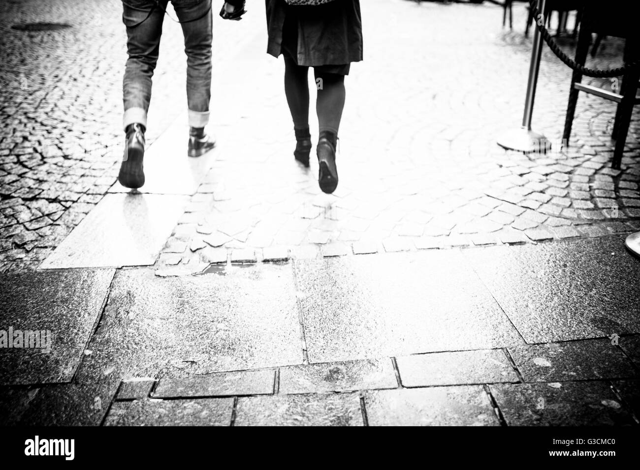 Two people walk hand in hand through Amsterdam's streets Stock Photo