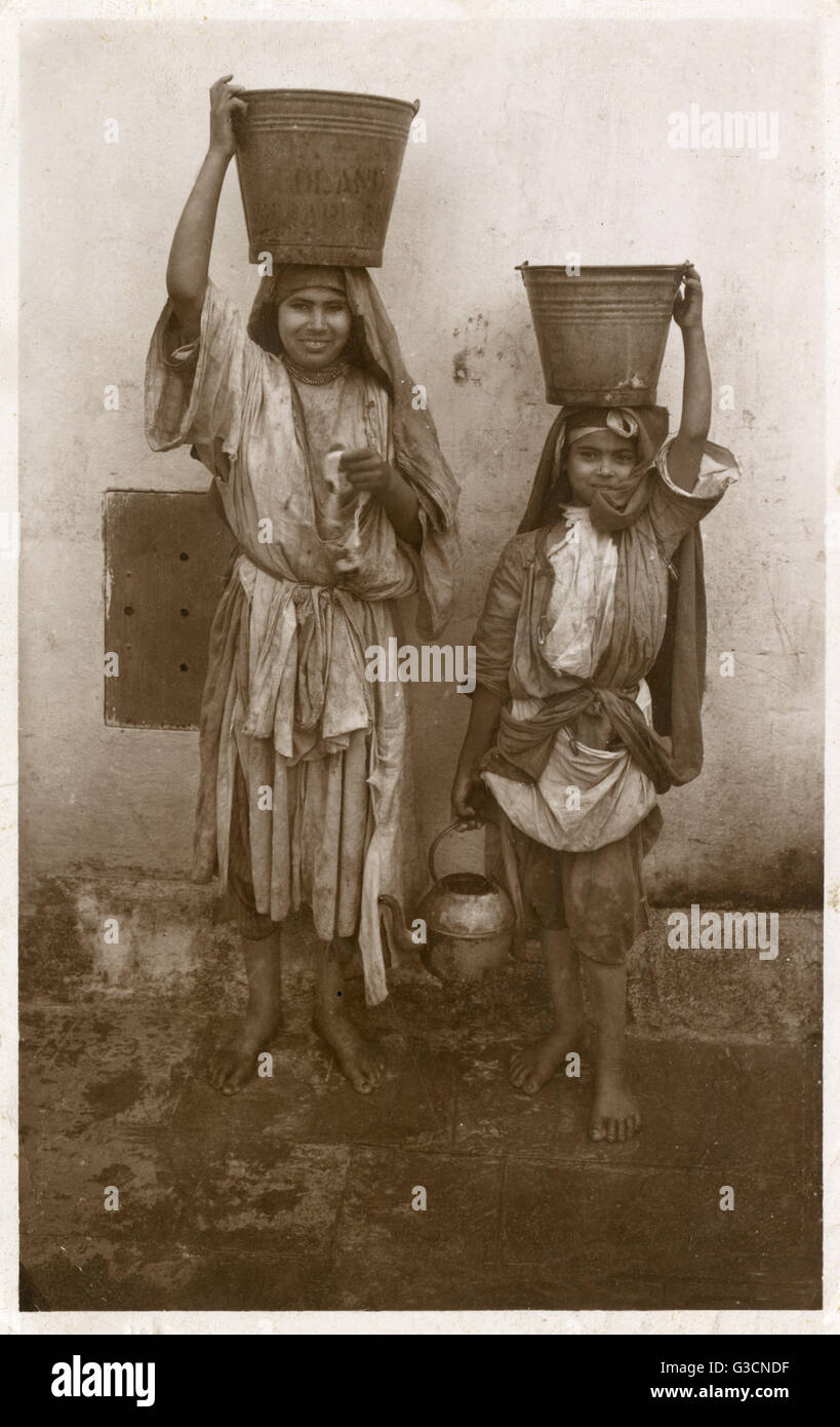 Two young Moroccan Girls with buckets on their heads Stock Photo