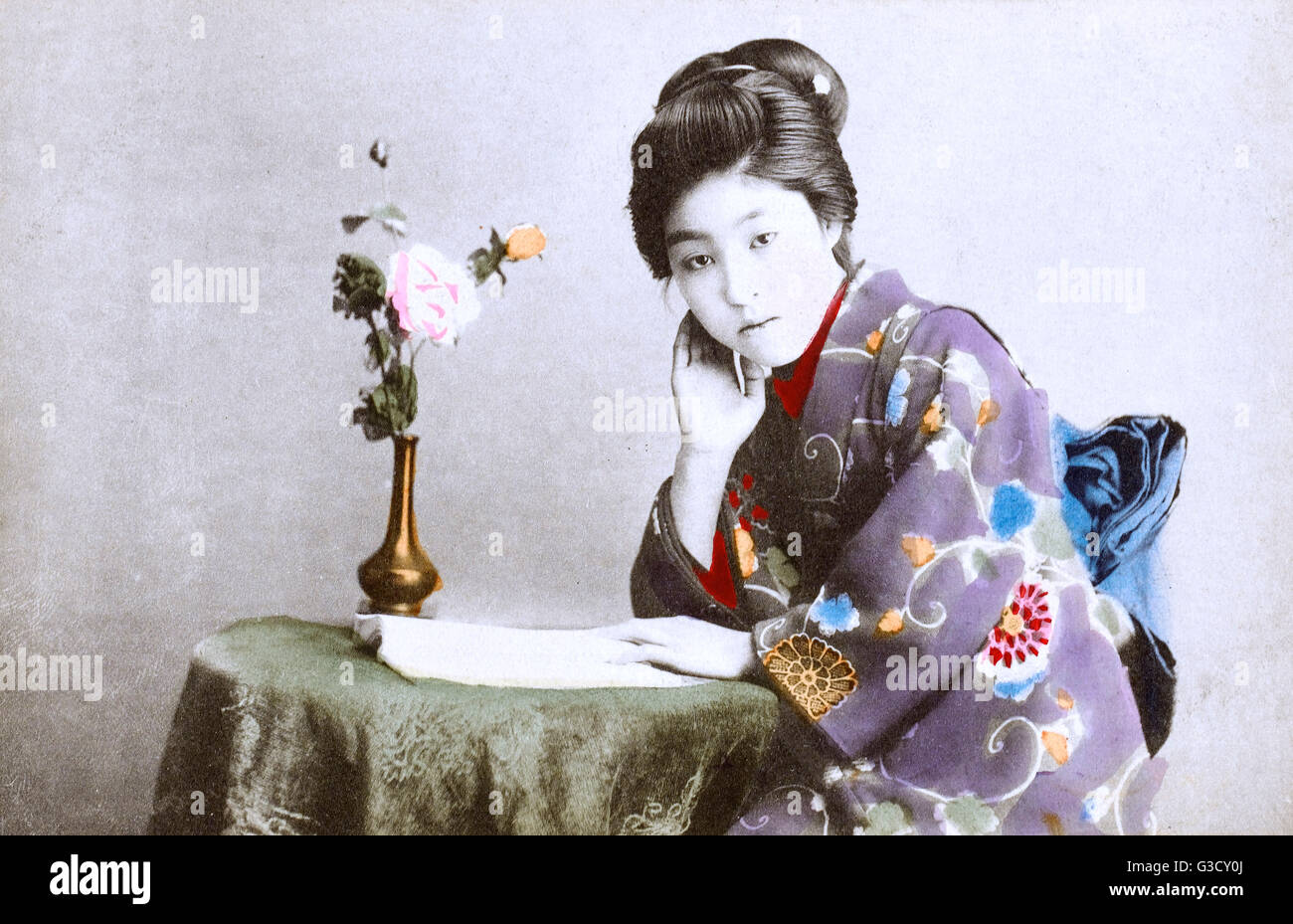 Japan - Geisha Girl - reading a book at a small table Stock Photo