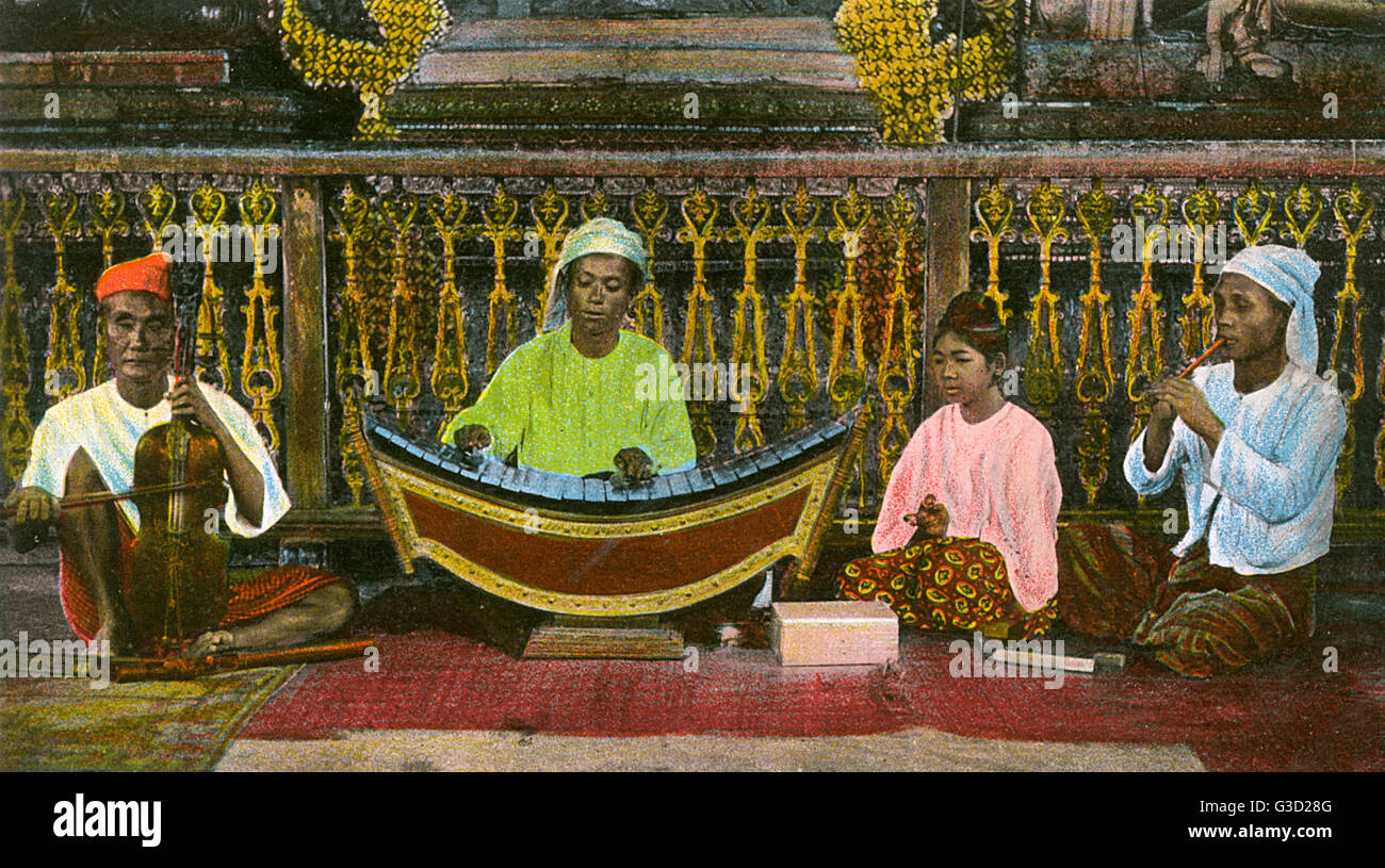Myanmar - A Traditional band playing a curved Burmese Xylophone or Pattala, the Mon violin, a 3-string fiddle with a western-like body played upright, hand bells/cymbals and small pipe/whistle.     Date: circa 1906 Stock Photo