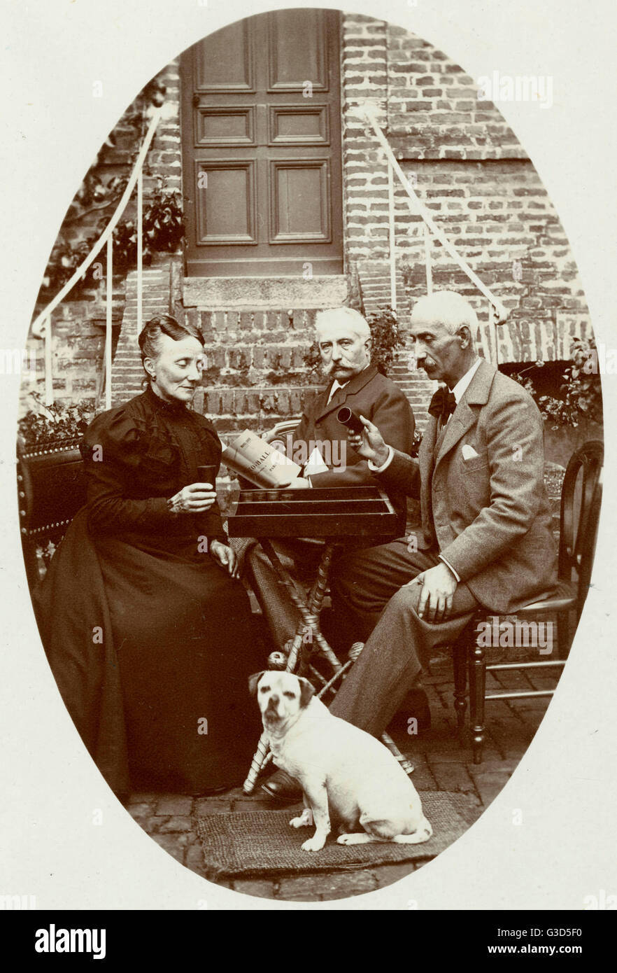 Three people with a dog in a garden Stock Photo - Alamy