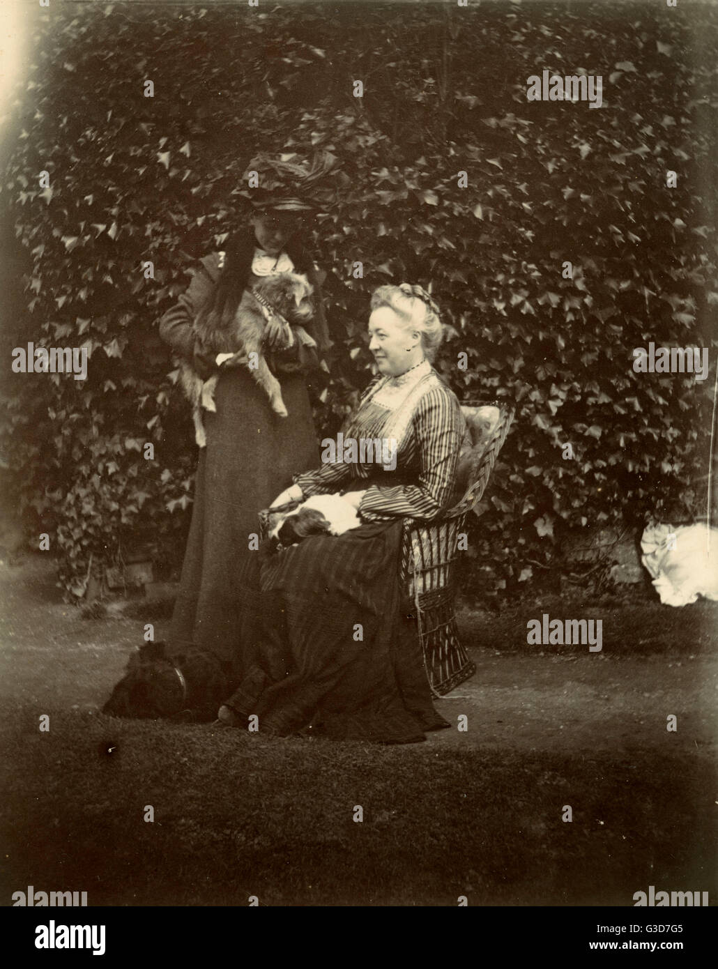 Two women with two dogs in a garden Stock Photo - Alamy