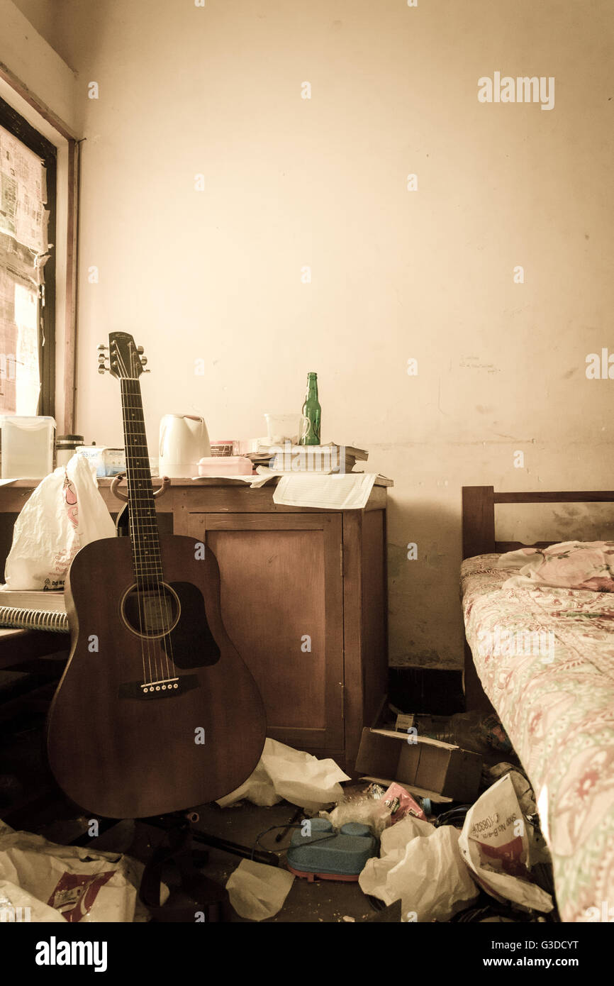 Messy Student Room with Guitar kept at Study Desk Stock Photo