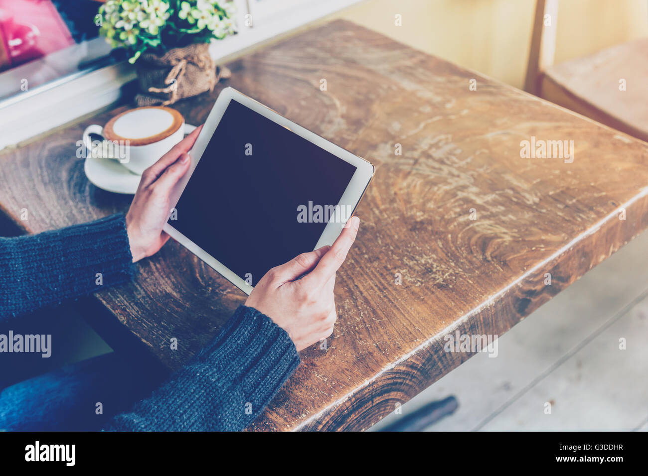 Woman using tablet in coffee shop with vintage tone. Stock Photo