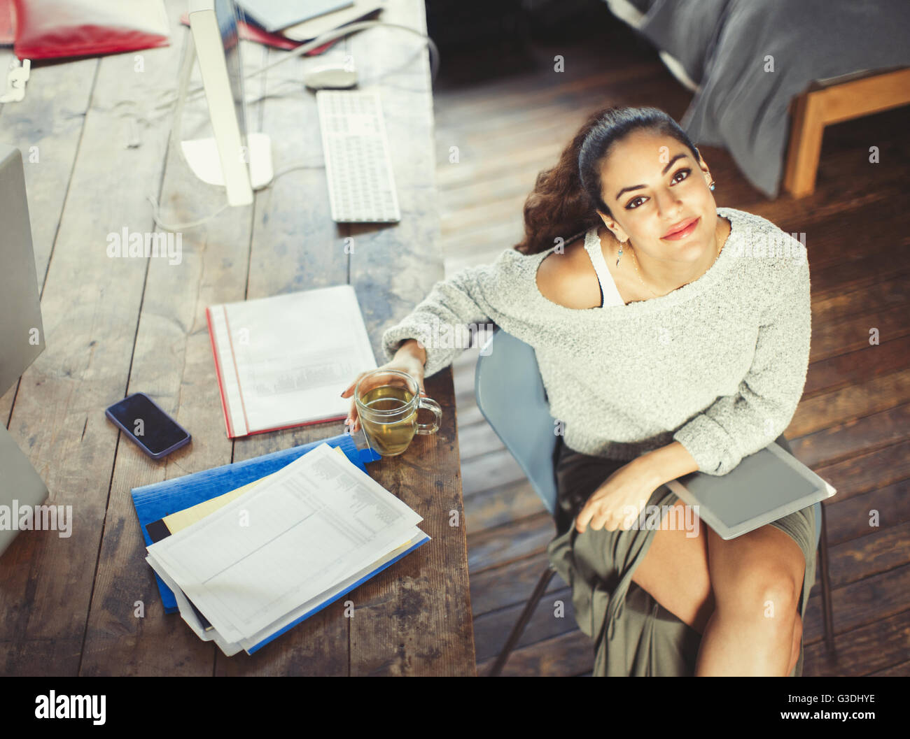 Portrait confident college student studying with tea and digital tablet Stock Photo