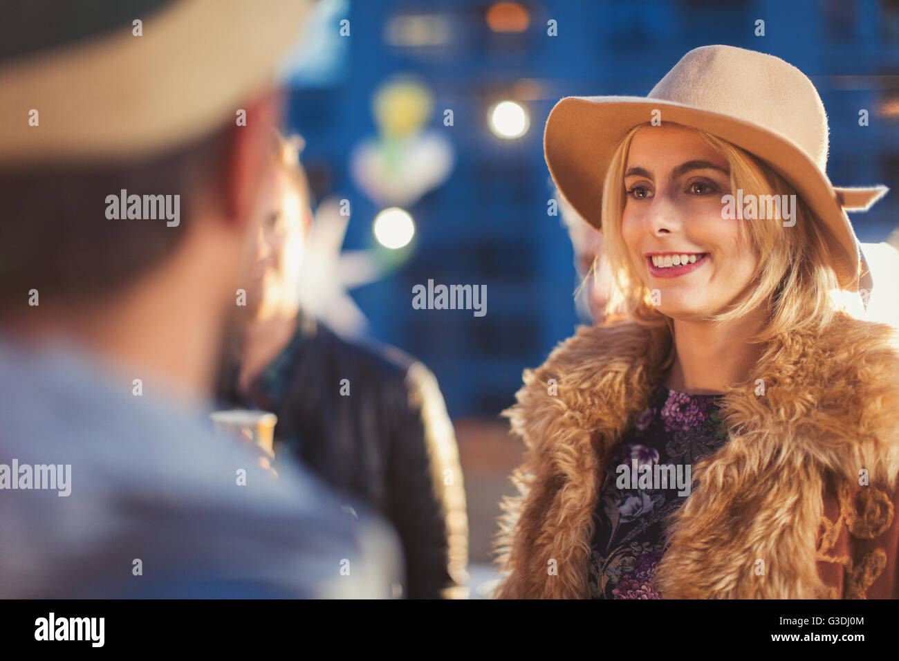 Smiling young woman socializing at party Stock Photo