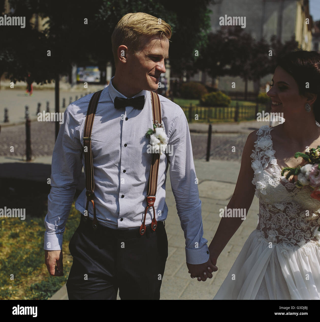 bride and groom walking around the city Stock Photo - Alamy