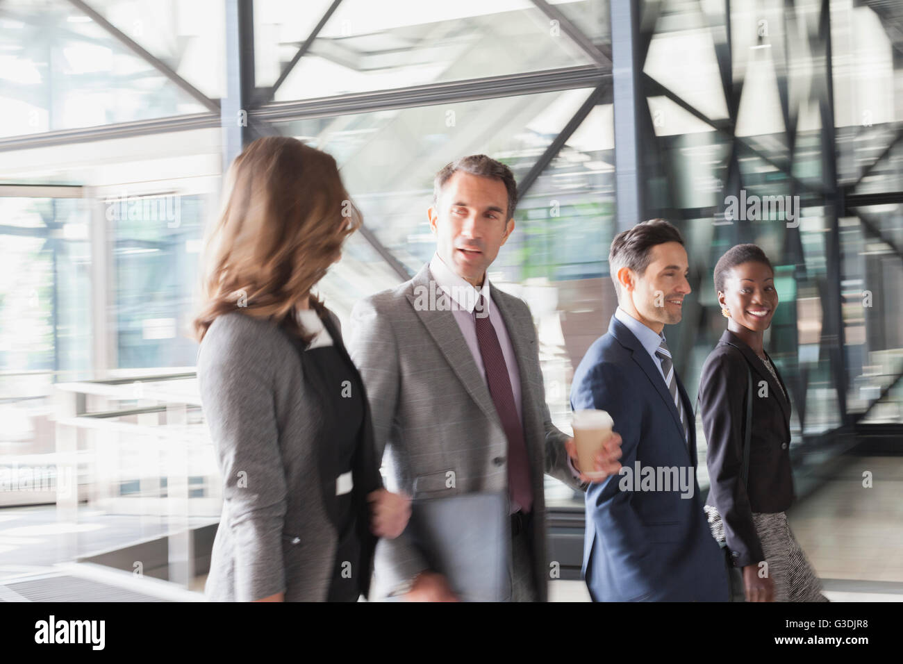 Corporate business people talking and entering modern office lobby Stock Photo