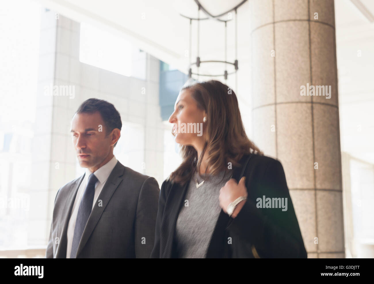 Corporate businessman and businesswoman talking and walking outdoors Stock Photo