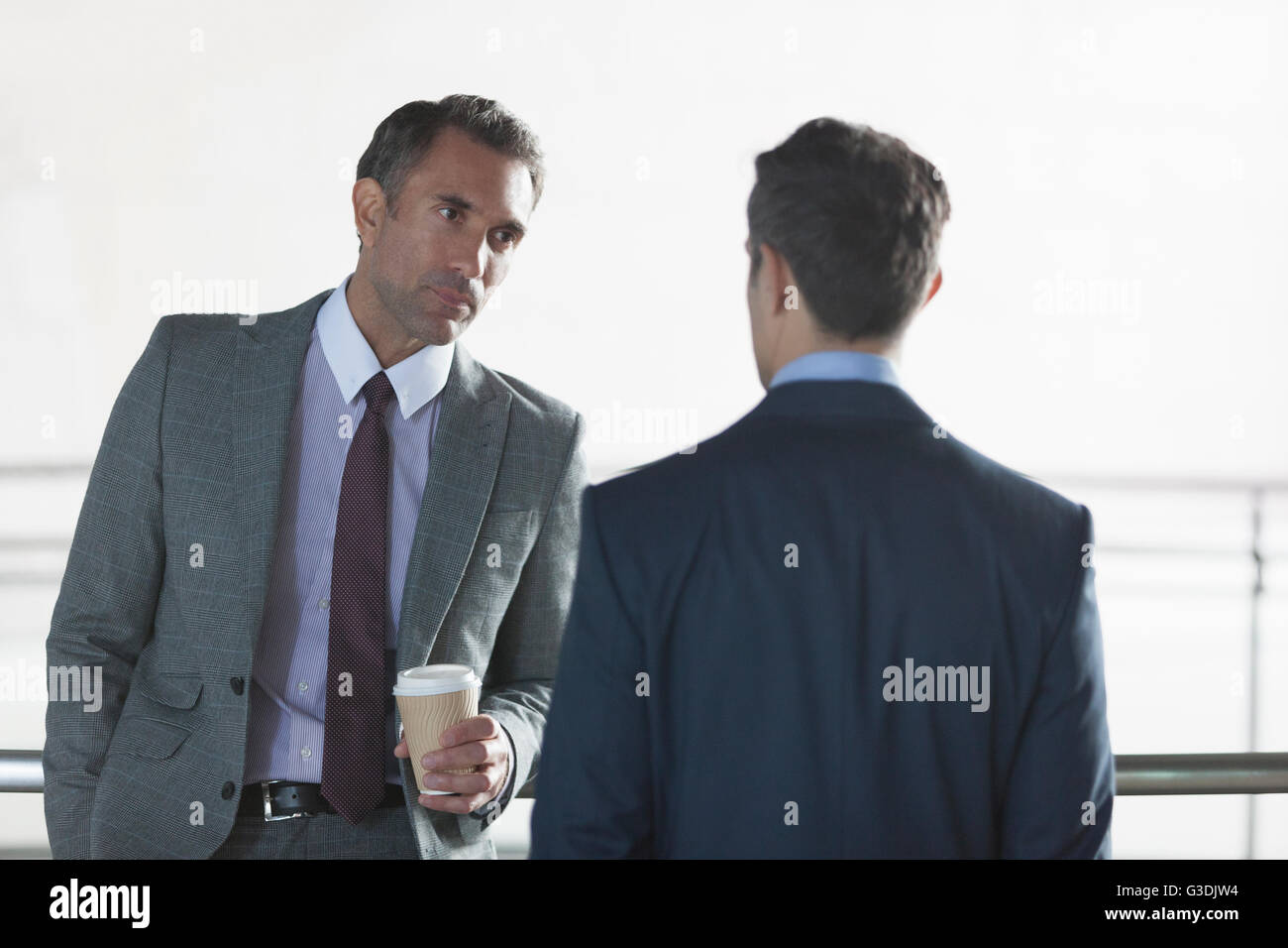 Serious corporate businessmen drinking coffee and talking Stock Photo
