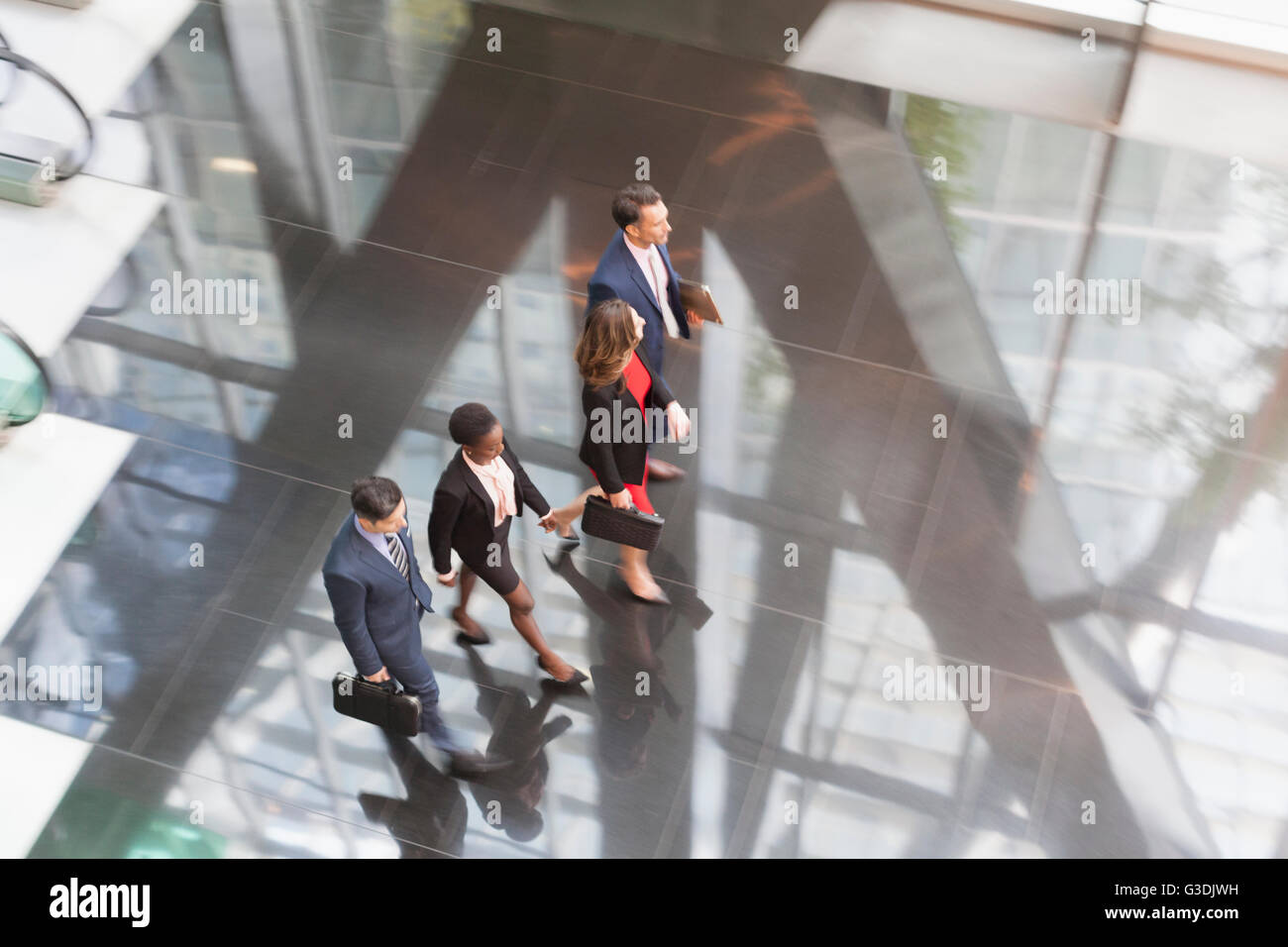 Corporate business people walking in modern office lobby Stock Photo