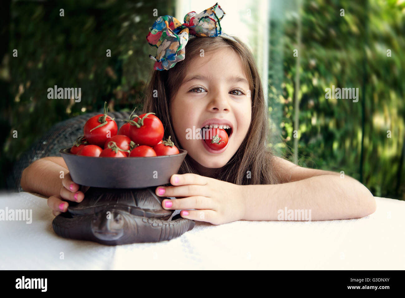 Girl biting cherry tomato Stock Photo