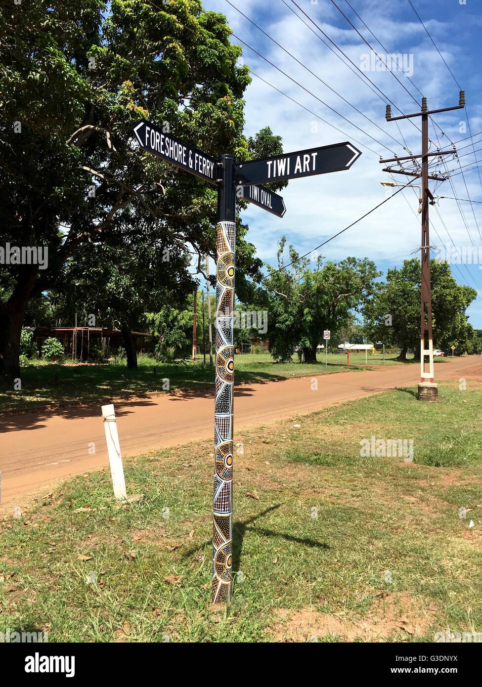 A decorated signpost on Bathurst Island, one of the two Tiwi Islands, pointing the way to the ferry and the art center. Stock Photo