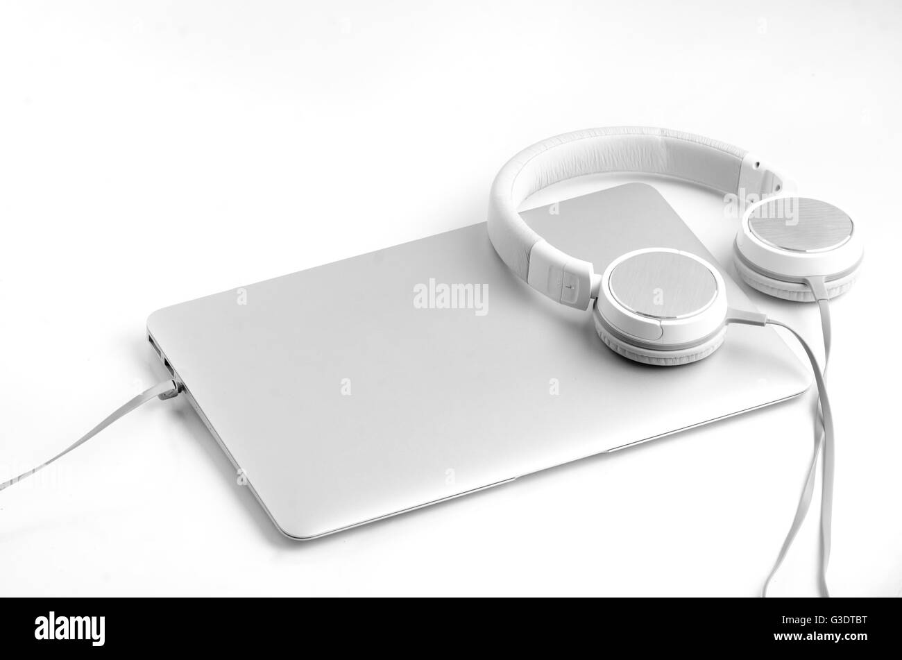 Silver laptop notebook and silveron-ear headphones isolated on white background Stock Photo