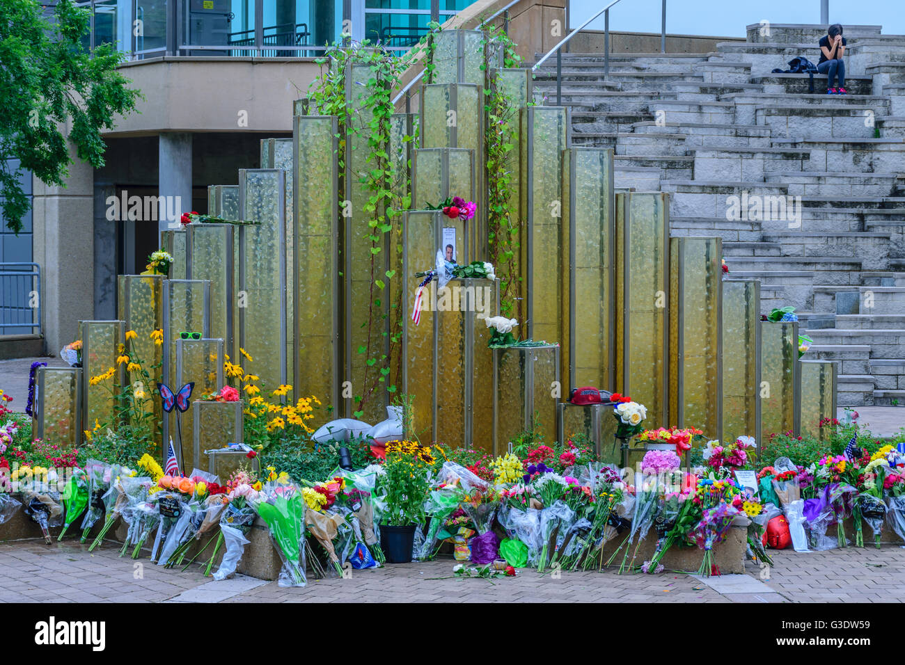 Louisville, Kentucky - A woman sits on the plaza of the Ali Center where the flowers are arranged after the death of Ali. Stock Photo
